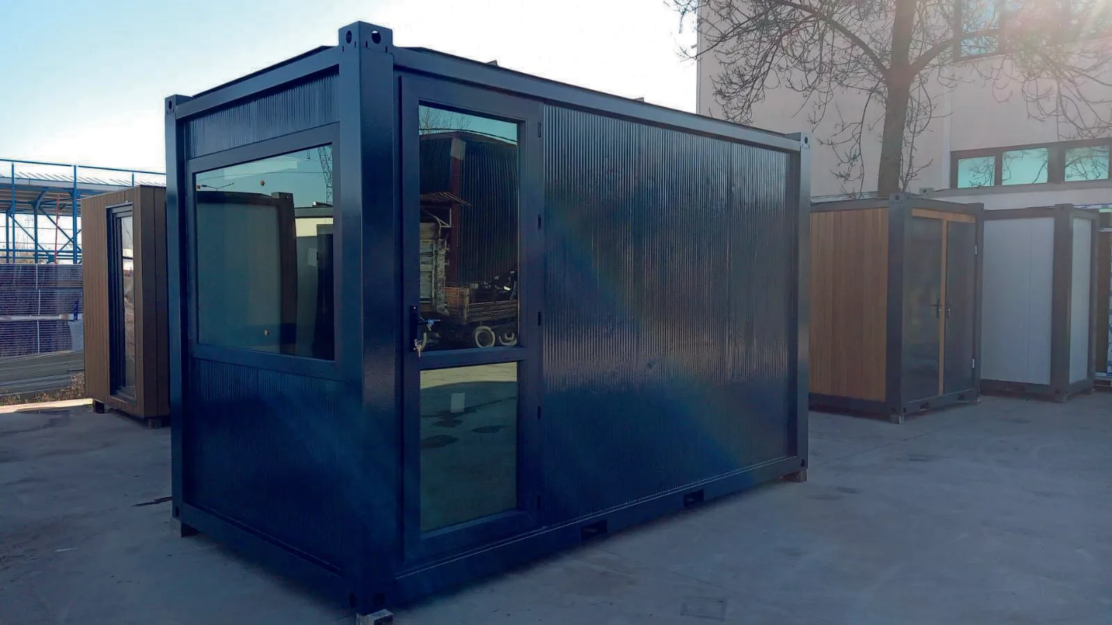 MODDOLIVING P2240 S flatpack container — premium dark-finish single-bay unit with full-height glazed door and pleated cladding panels.