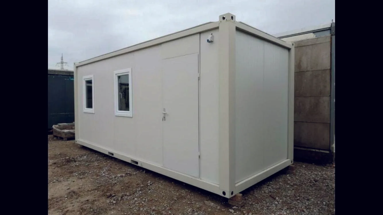 P2240 S flatpack container — compact single-bay exterior view with door and twin windows on a gravel site base.