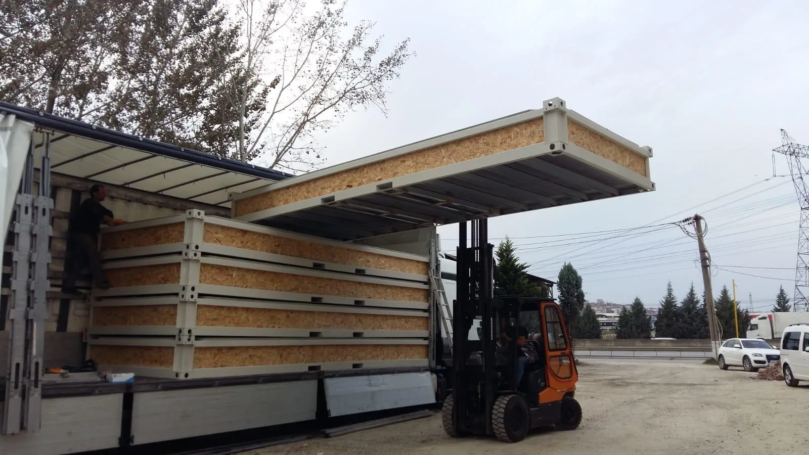 MODDOLIVING P2460 L flatpack container — exterior view on standard ISO footprint with twin windows and entry door.
