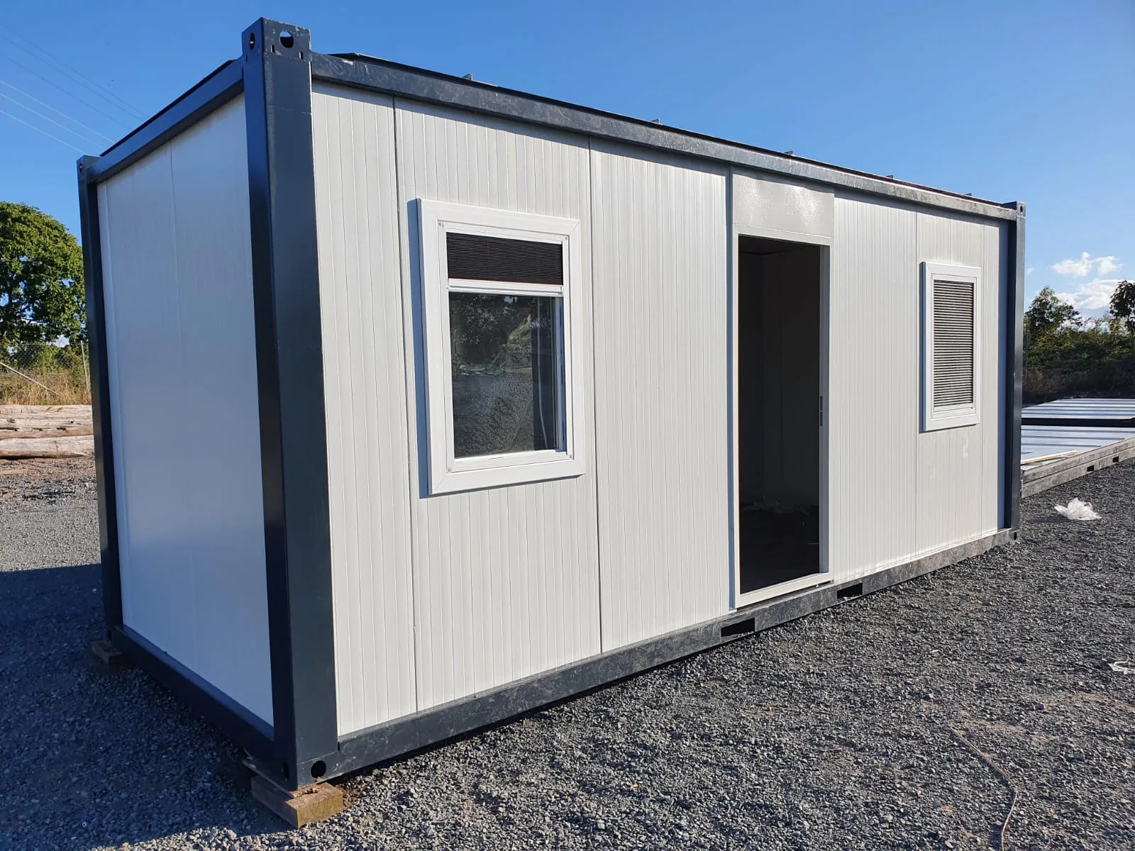 P2460 L flatpack container — alternate site view with adjacent equipment and yard infrastructure.