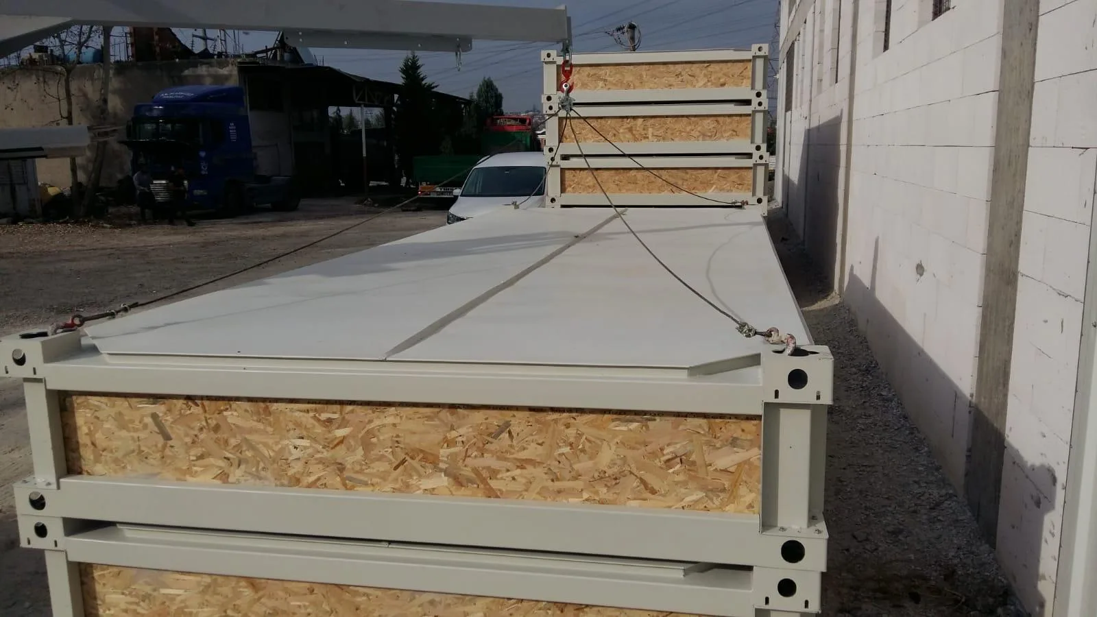 P2460 L flatpack container — alternate exterior angle in a yard with hard-standing base.