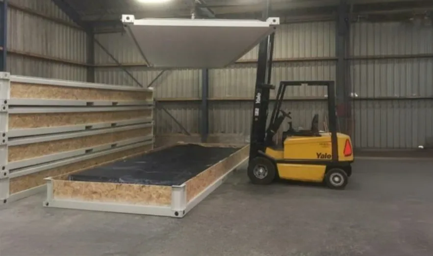 P2460 L flatpack container — site-installation perspective showing entry door and stepped access.