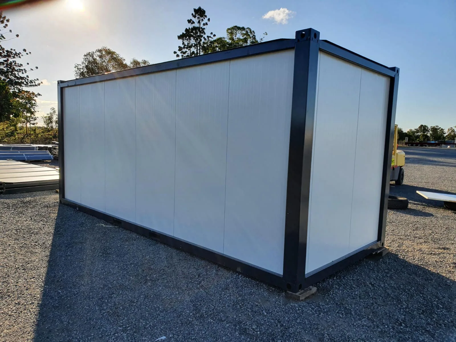 P2460 L flatpack container — interior context through open door showing finished wall panel surface.